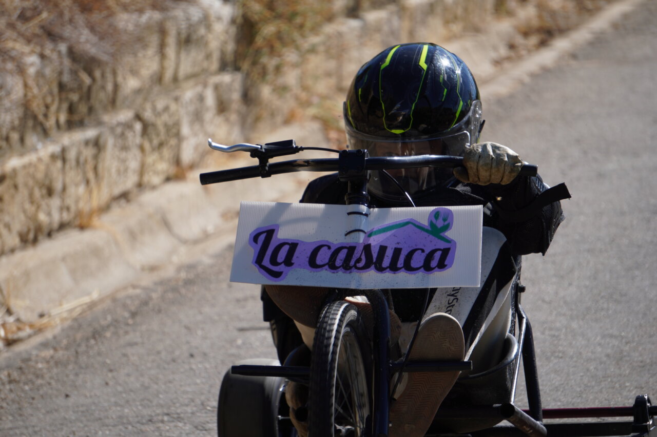 Participante en carrera de autos locos con casco y vehículo