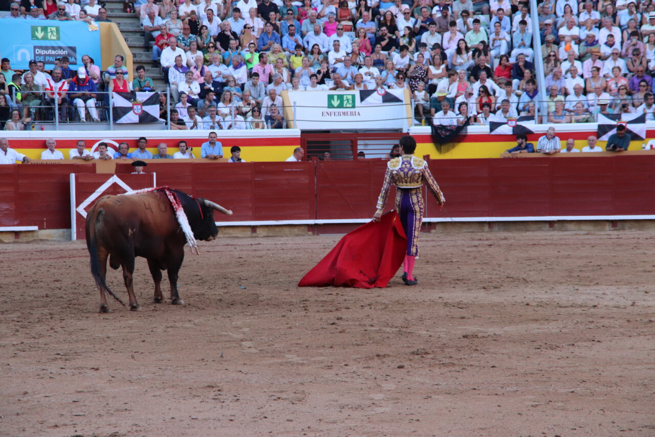 Torero con capa roja en la plaza de toros de Palencia