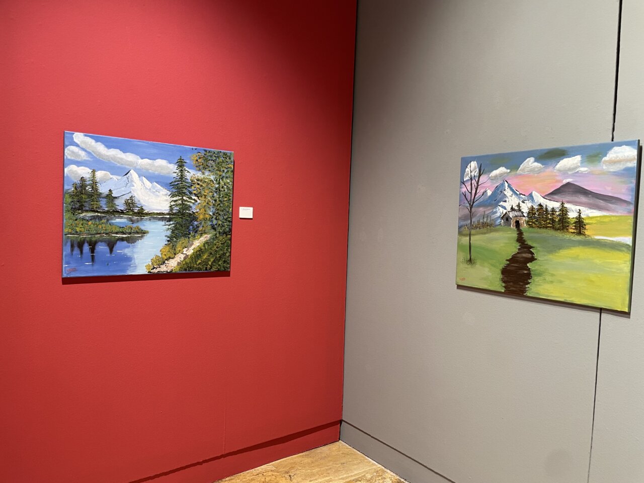 Dos pinturas naíf de Mercedes Maté en una exposición cultural.
