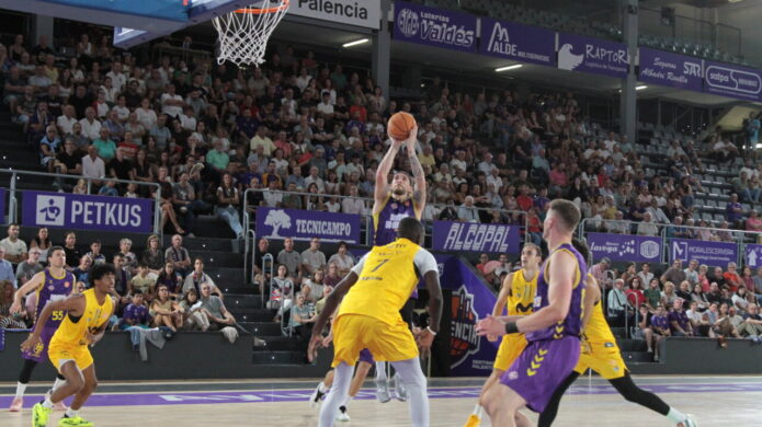 Jugador lanzando a canasta durante un partido de baloncesto en Palencia