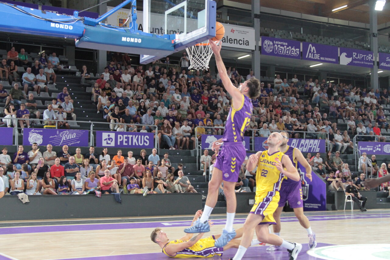 Jugador lanzando a canasta en un partido de baloncesto entre Palencia y Valladolid