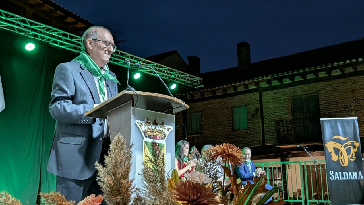 Hombre dando un pregón en las fiestas de Saldaña con decoraciones florales