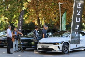 Exposición de vehículos sostenibles en Palencia con árboles de fondo