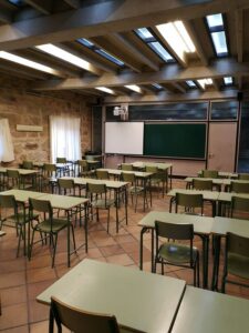 Aula vacía con mesas y sillas en un centro educativo