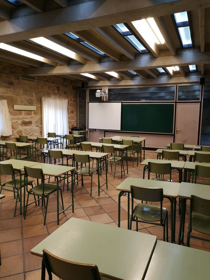 Aula vacía con mesas y sillas en un centro educativo