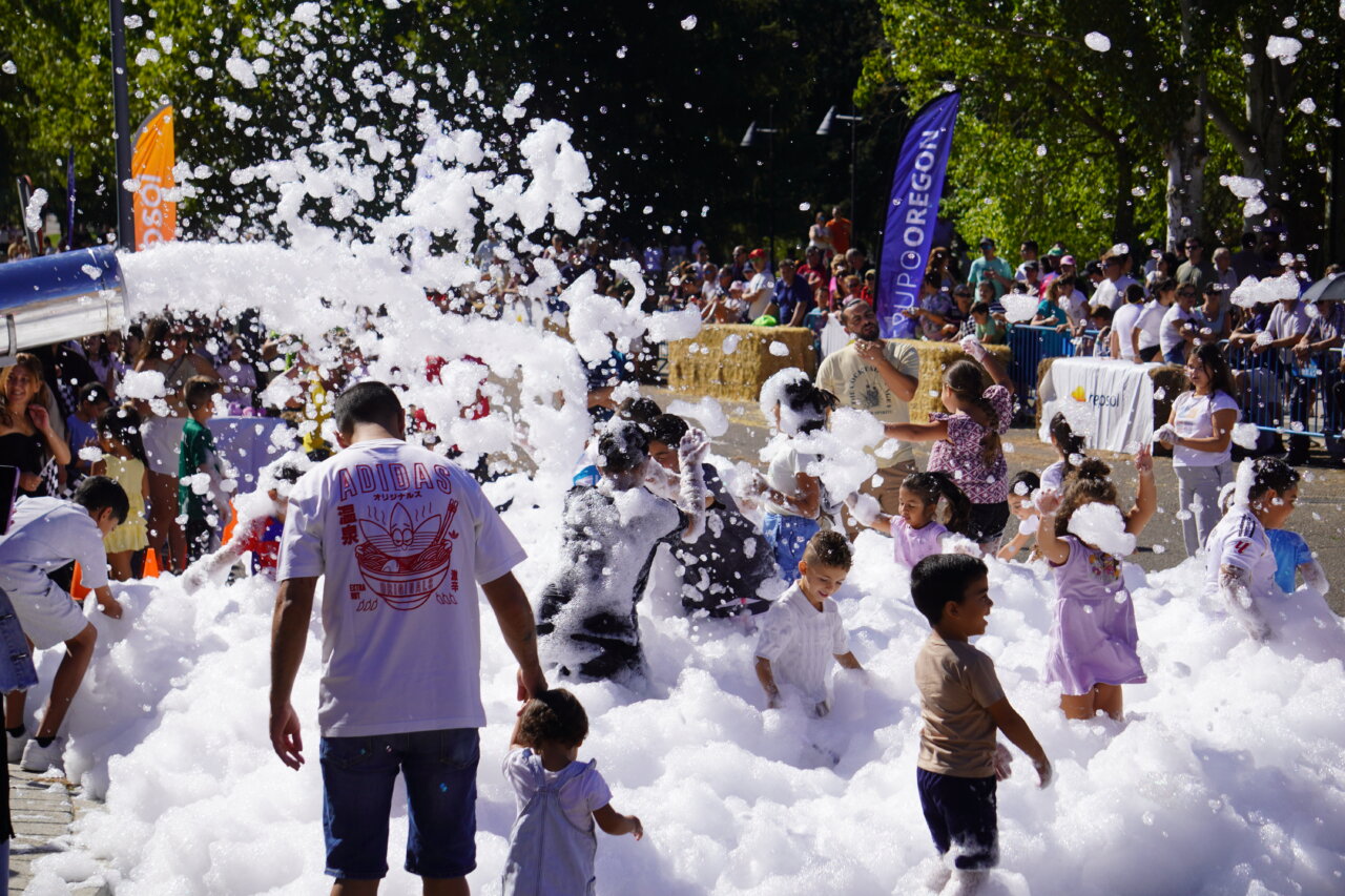Niños jugando en espuma durante la carrera de autos locos en Palencia