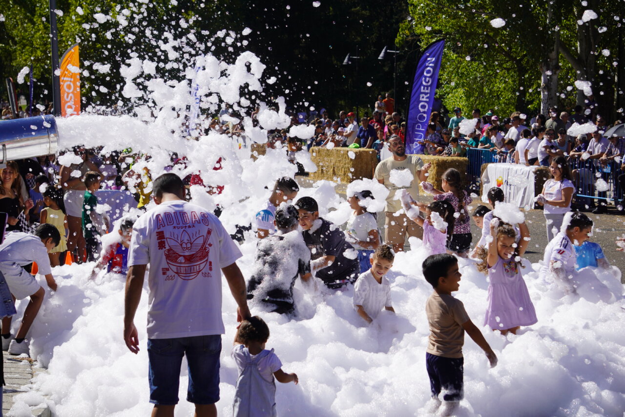 Niños jugando en una carrera de autos locos con espuma en Palencia
