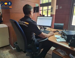 Policía Nacional trabajando en un escritorio con documentos y computadora