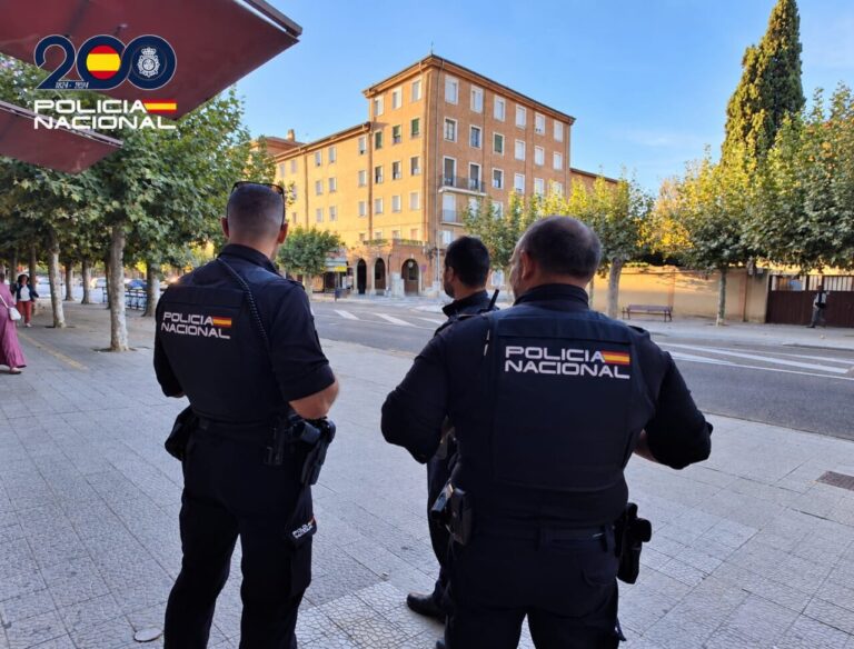 Agentes de la Policía Nacional en la calle observando un entorno urbano