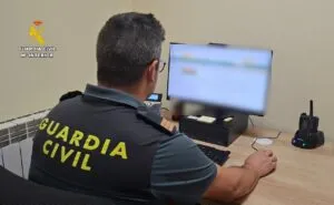 Agente de la Guardia Civil trabajando en un ordenador sobre una estafa de vehículo