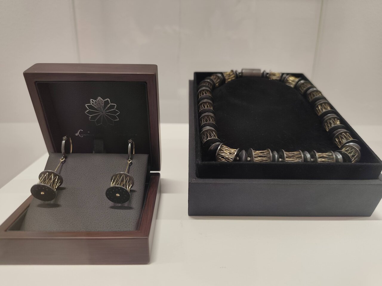 Pendientes y collar de artesanía contemporánea en exhibición