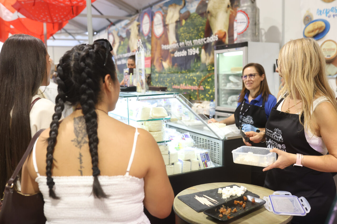 Mujeres en la Feria Internacional del Queso Fromago interactuando con productos lácteos