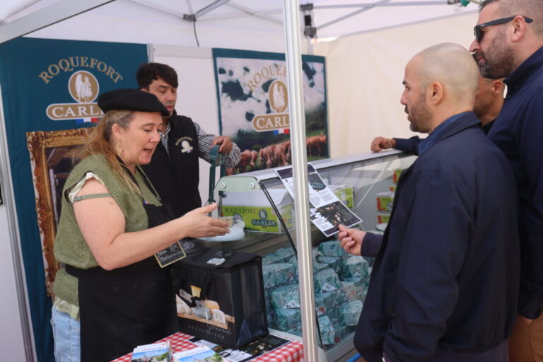 Mujer presentando queso Roquefort en una feria