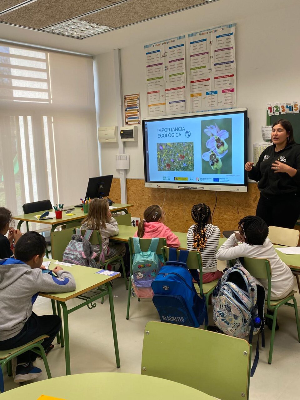 Clase de estudiantes aprendiendo sobre la importancia ecológica en un aula