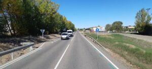 Carretera CL-613 con señalización y vegetación a los lados