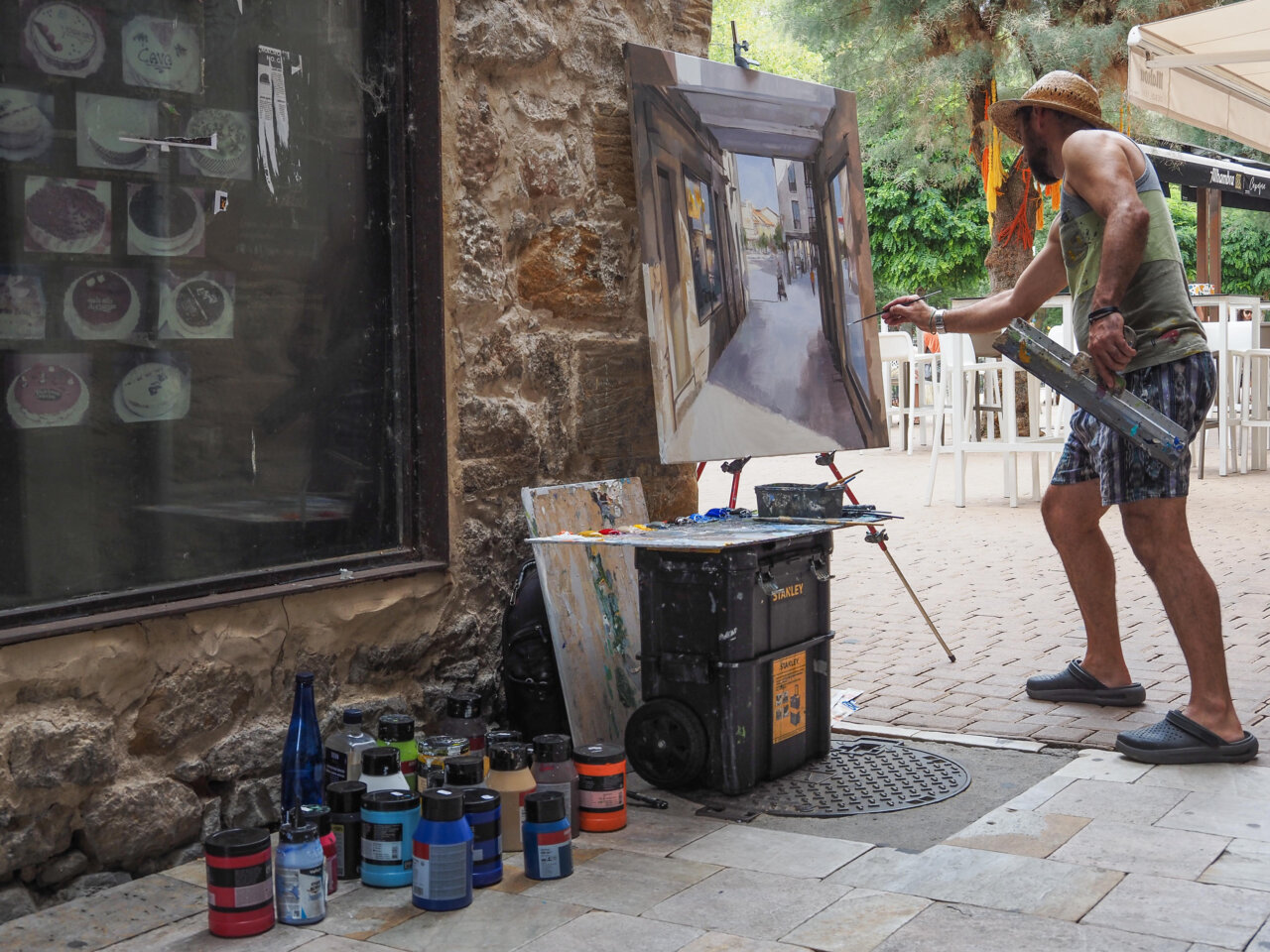 Artista pintando en la calle durante un certamen de pintura rápida