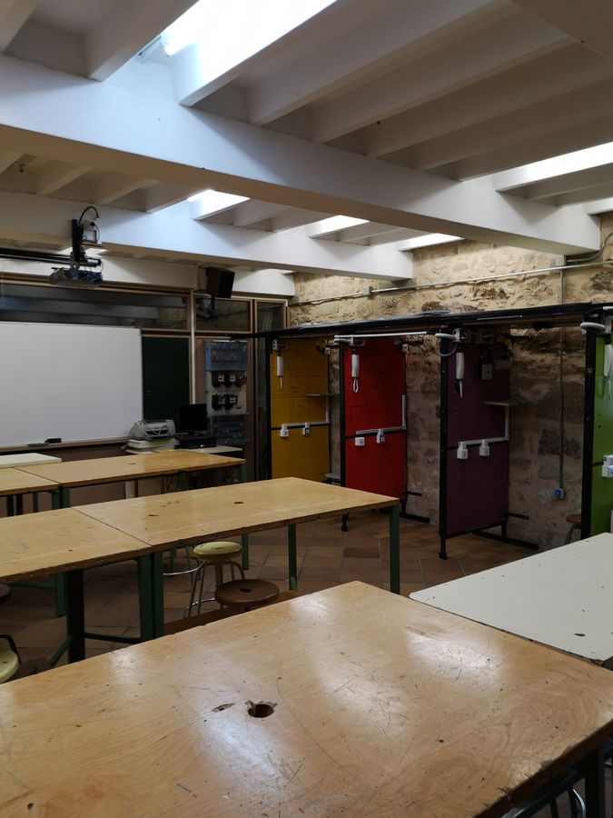 Aula de formación profesional con mesas y equipos educativos