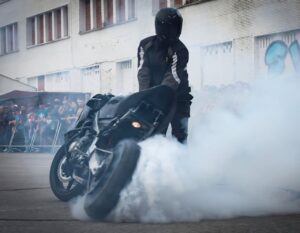 Motociclista realizando una exhibición de stunt en un evento motero