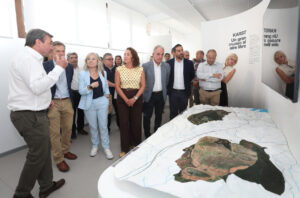 Inauguración de la Casa del Parque KARST con un grupo de personas observando un modelo de paisaje.