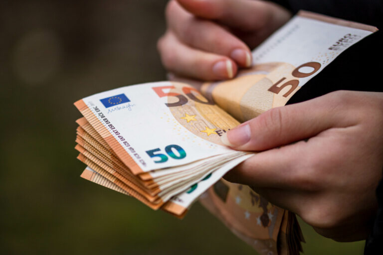 Primer plano de manos femeninas contando billetes de euro