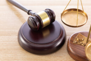 Martillo de juez y balanza sobre superficie de madera