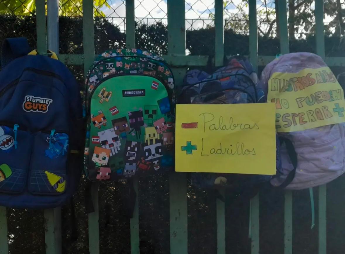 Mochilas con carteles en una movilización por un nuevo colegio en Dueñas