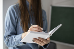 Mujer escribiendo en un cuaderno en un entorno interior