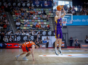 Jugador lanzando a canasta en el partido de baloncesto