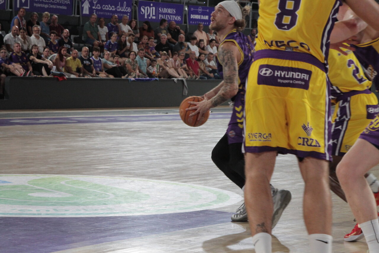 Jugador de baloncesto lanzando un balón en un partido entre Palencia y Valladolid