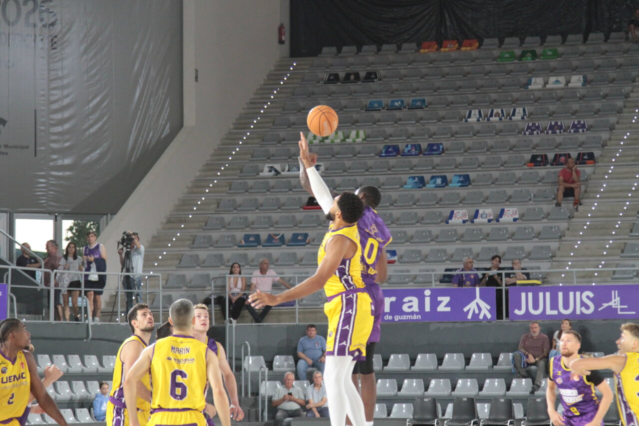 Jugadores de baloncesto en el salto inicial durante un partido