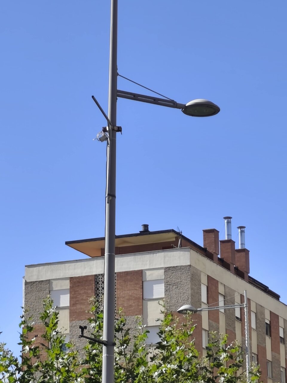 Farola en Palencia con cielo azul y edificio de fondo