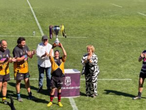 Jugadores levantando el trofeo de la Maurice Cup en el campo de rugby.