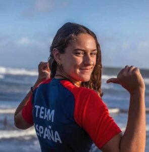 Sandra Santos mostrando su camiseta del equipo de España en la playa