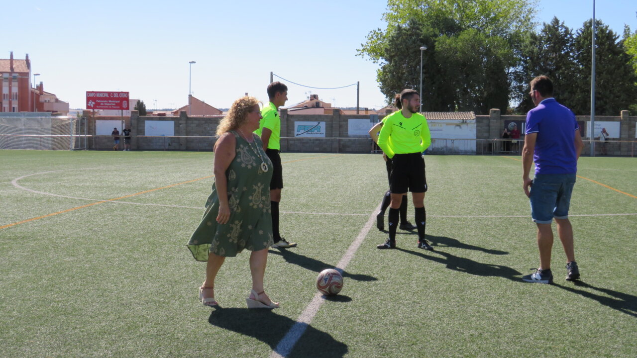 Una mujer realizando el saque de honor en un partido de fútbol femenino.