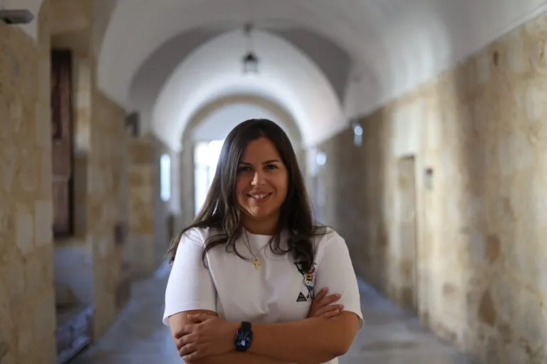 Sara Fregeneda posando en un pasillo con paredes de piedra