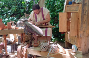 Hombre elaborando calzado romano en un taller práctico