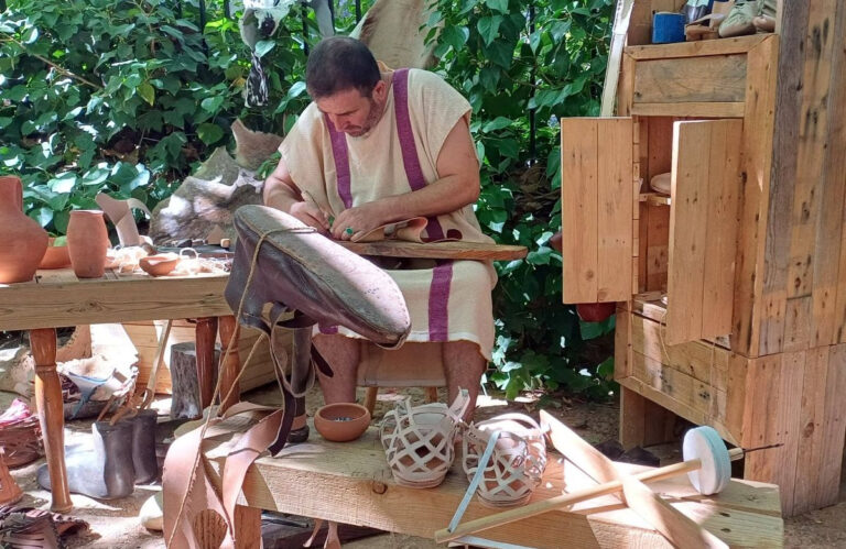 Hombre elaborando calzado romano en un taller práctico