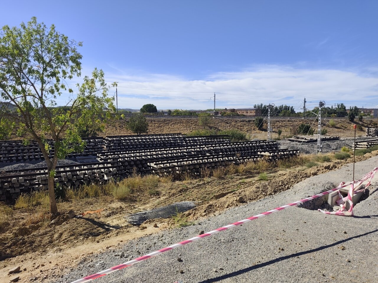 Vista de una vía ferroviaria desmantelada en Palencia con traviesas apiladas