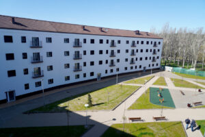 Edificio de viviendas de protección pública en Castilla y León con áreas verdes.