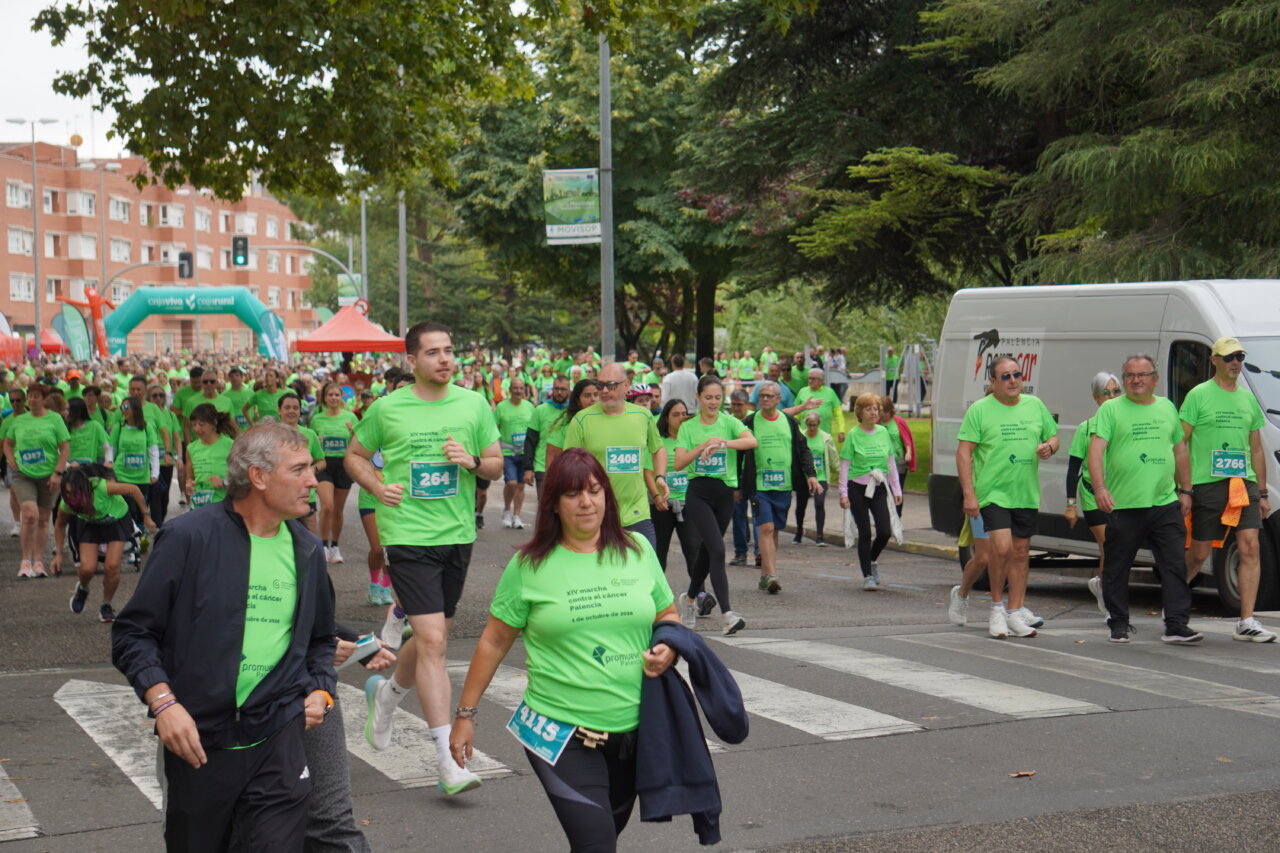 Participantes en la carrera contra el cáncer vistiendo camisetas verdes en Palencia