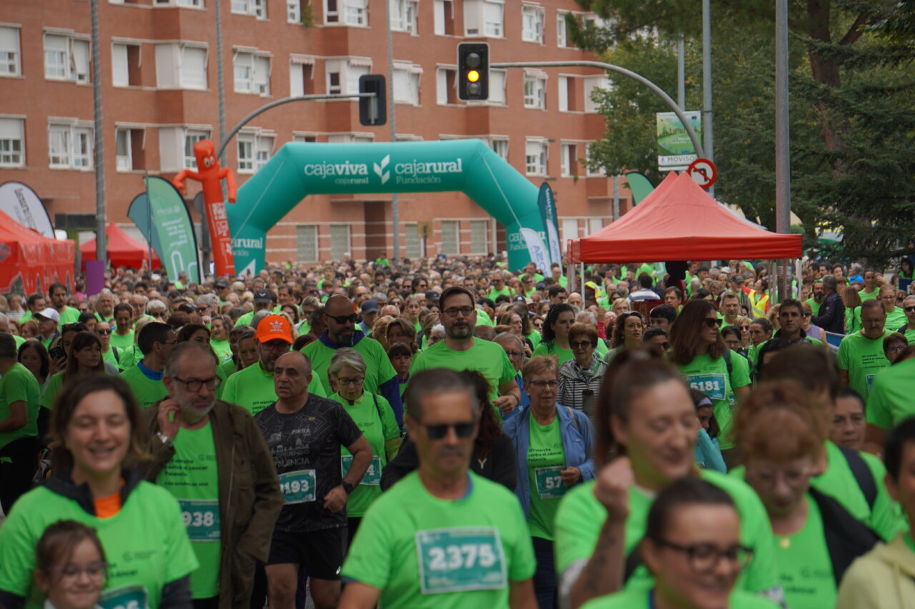 Participantes en la carrera contra el cáncer vistiendo camisetas verdes en Palencia.