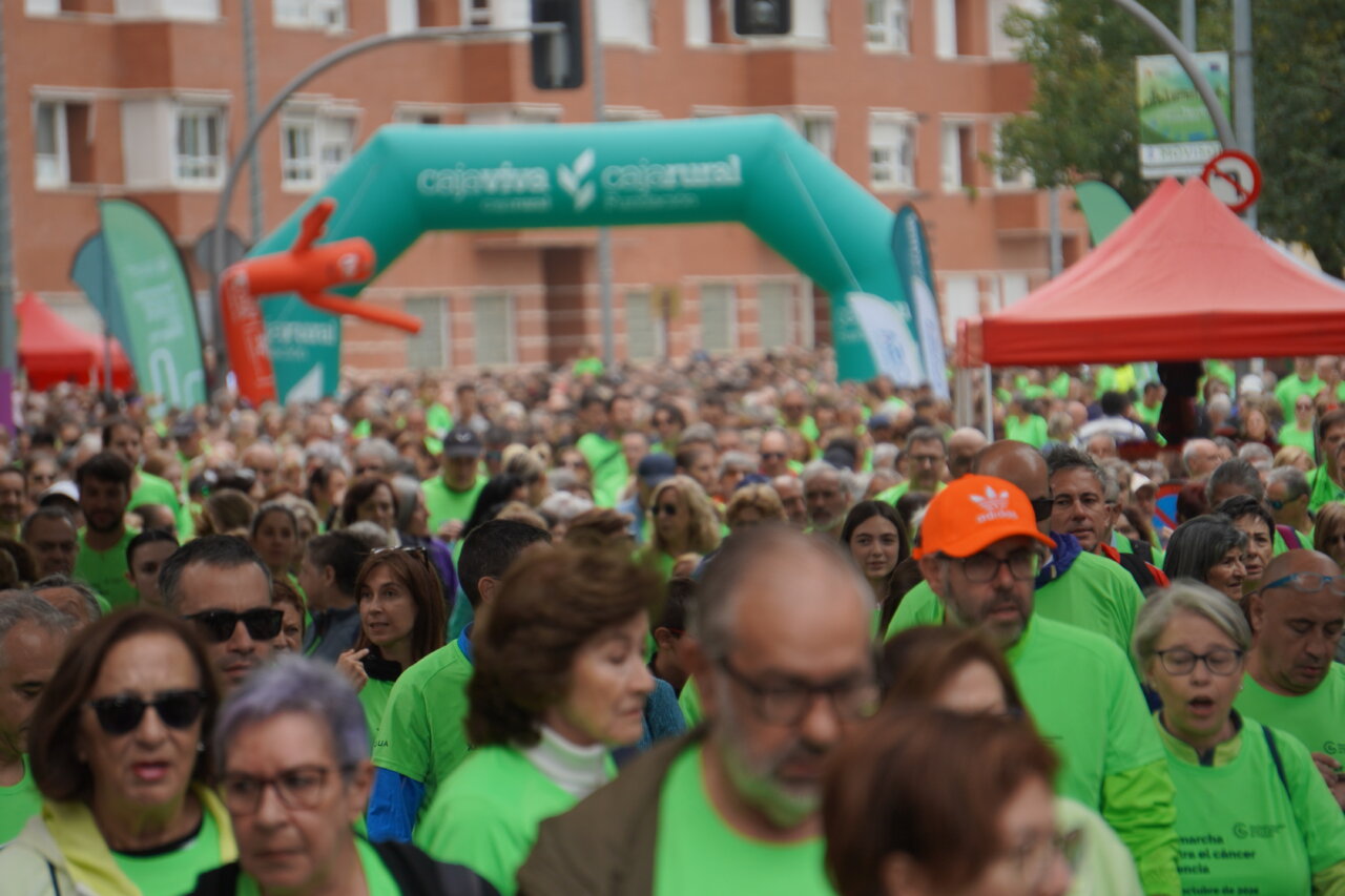 Multitud de personas con camisetas verdes en una carrera contra el cáncer en Palencia