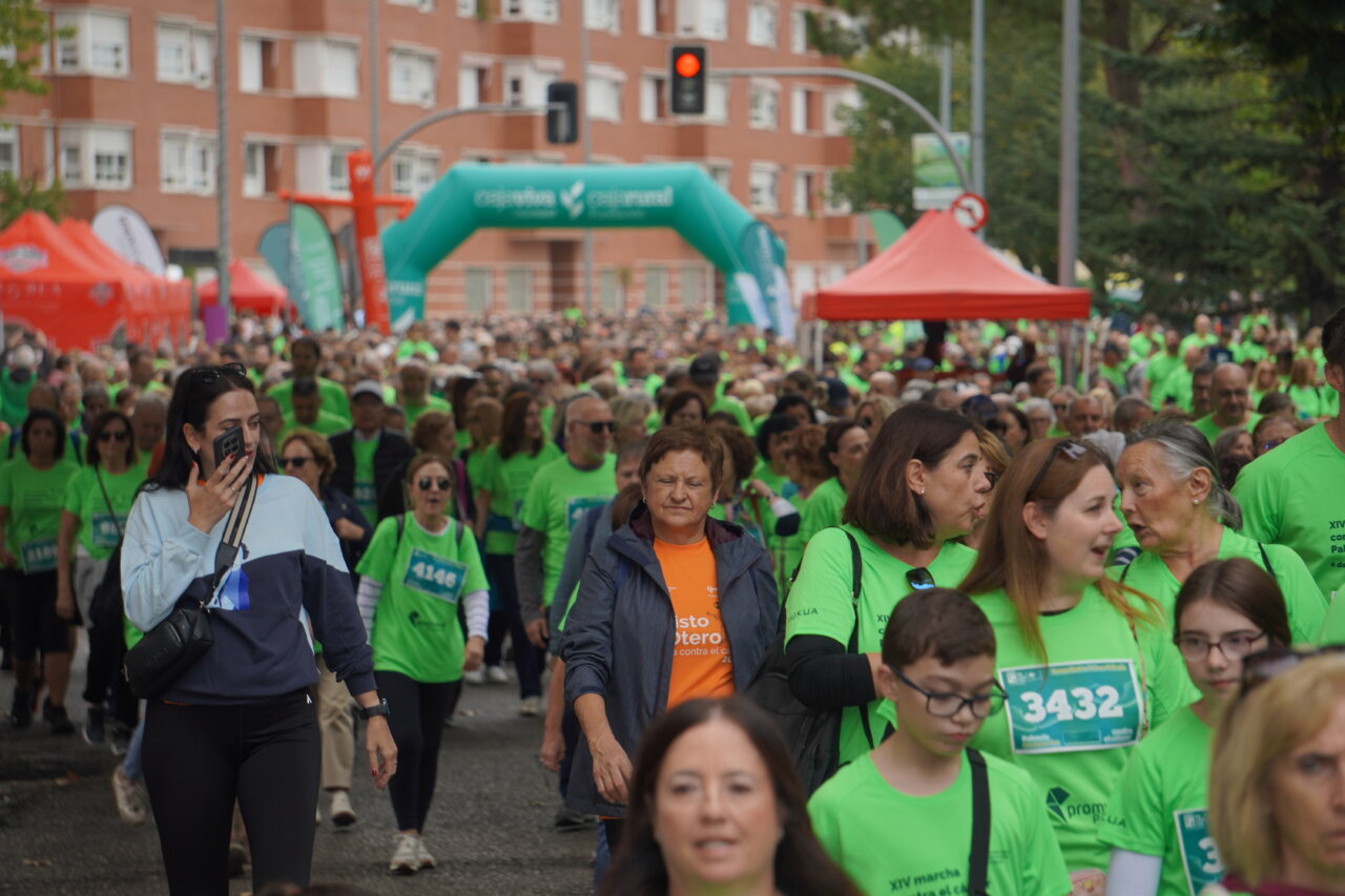 Participantes de la carrera contra el cáncer vistiendo camisetas verdes en Palencia.