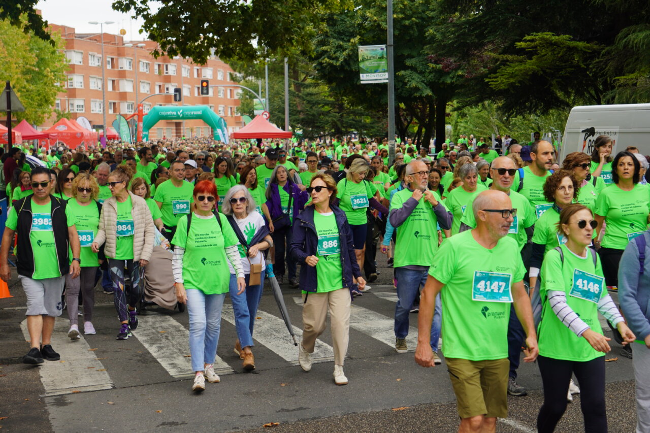 Participantes de la carrera contra el cáncer vistiendo camisetas verdes en Palencia