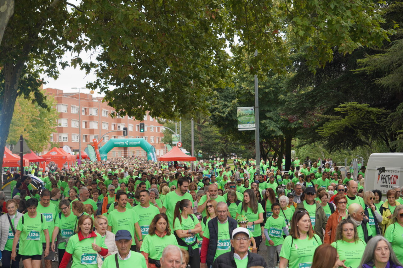Multitud de personas con camisetas verdes en la Carrera contra el Cáncer en Palencia.