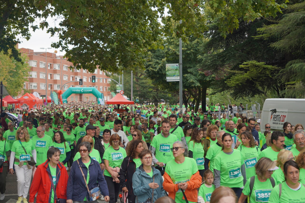 Participantes en la carrera contra el cáncer vistiendo camisetas verdes en Palencia