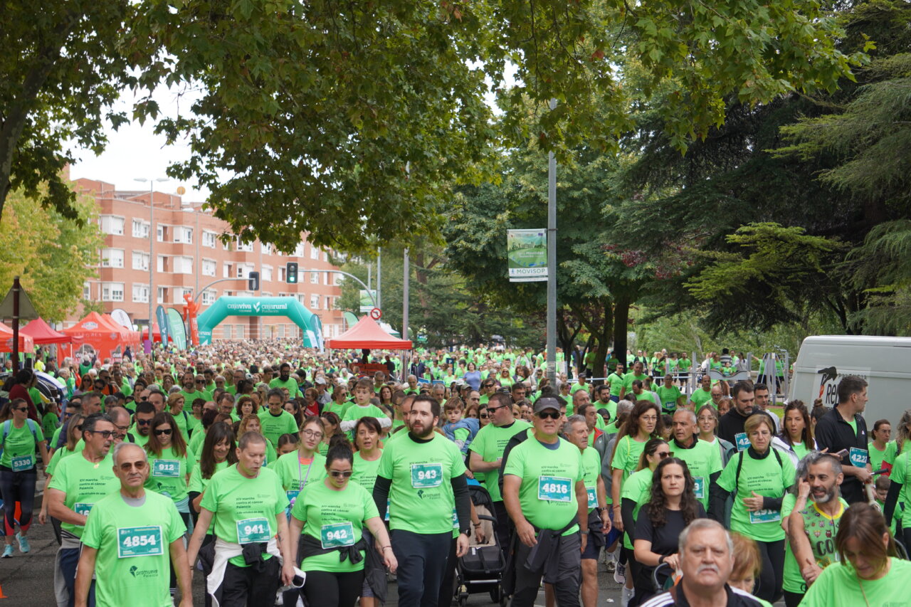 Participantes en la carrera contra el cáncer vistiendo camisetas verdes en Palencia