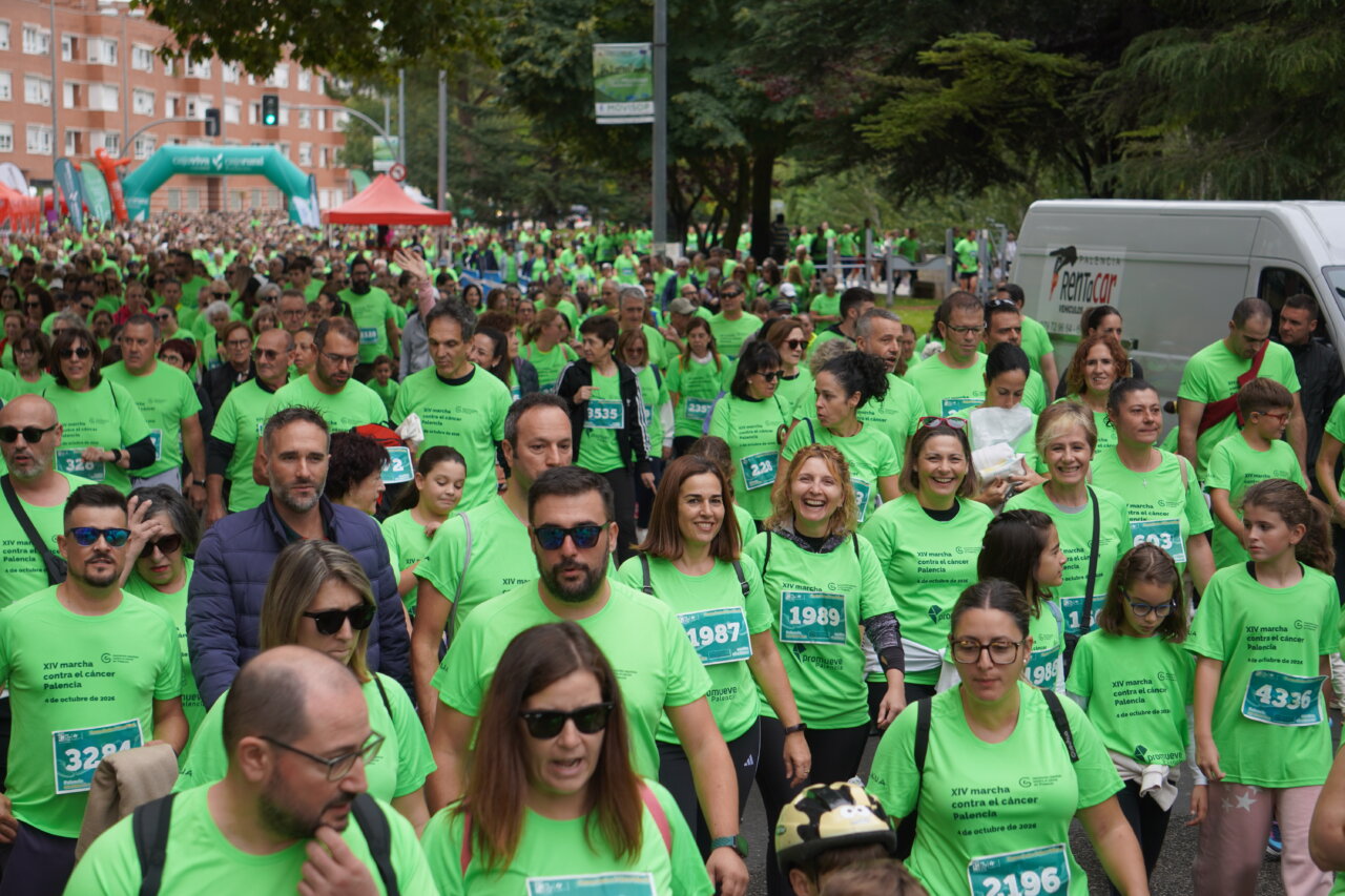 Participantes en la carrera contra el cáncer vistiendo camisetas verdes en Palencia