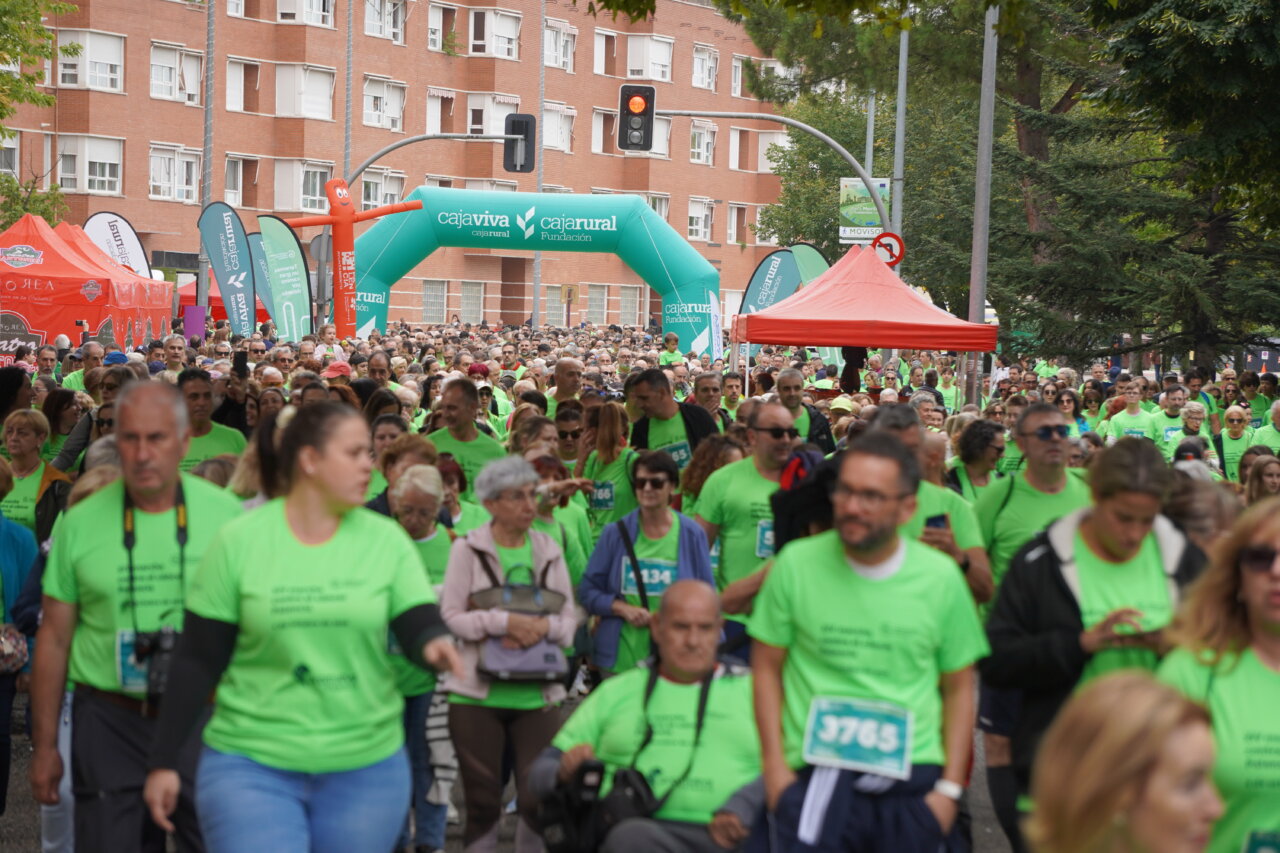 Participantes en la carrera contra el cáncer vistiendo camisetas verdes en Palencia.
