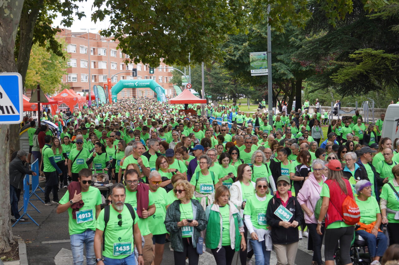 Participantes en la carrera contra el cáncer vistiendo camisetas verdes en Palencia